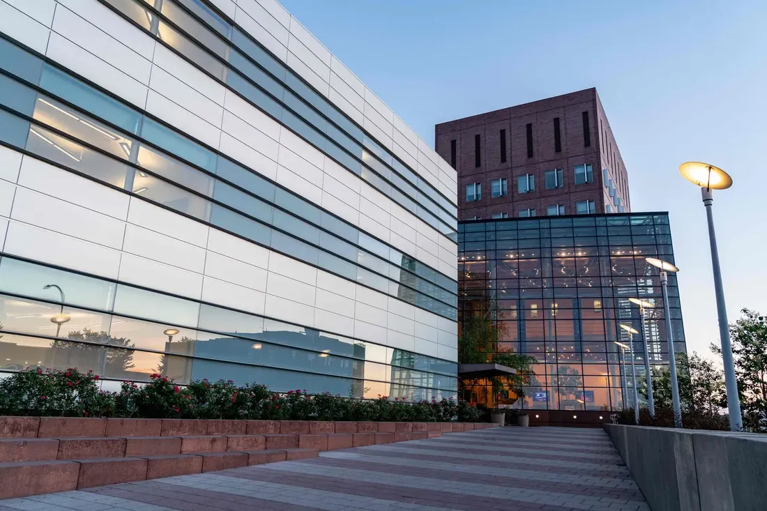 Whitman School of Management building exterior in the evening.